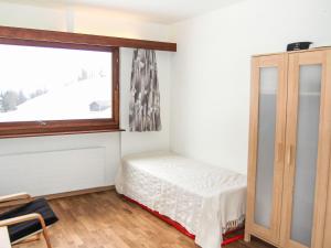 Schlafzimmer mit einem Bett und einem Fenster in der Unterkunft Apartment Rosablanche D35 by Interhome in Siviez
