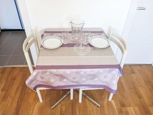 uma mesa com uma toalha de mesa roxa e branca em Apartment Rosablanche D35 by Interhome em Siviez