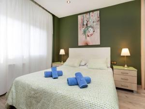 una camera da letto con un letto con cuscini blu di Apartment Sants-Montjuic Rambla Badal by Interhome a Barcellona