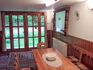 a dining room with a wooden table and windows at Holiday Home Baracka by Interhome in Martinske Hole