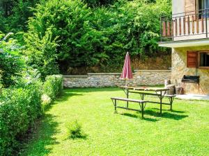 a yard with two benches and a table and an umbrella at Holiday Home Baracka by Interhome in Trenčianske Teplice