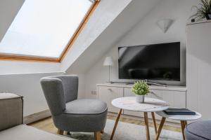 a living room with a tv and a chair and a table at Haus Sabina in Helgoland