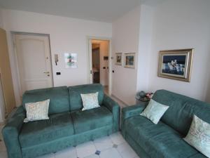 ein Wohnzimmer mit 2 grünen Sofas in der Unterkunft Apartment Punta Borromea by Interhome in Stresa