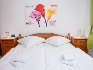 ein Schlafzimmer mit einem weißen Bett mit zwei Handtüchern darauf in der Unterkunft Apartment Ebbe by Interhome in Norddeich