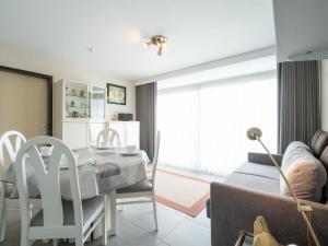 a bedroom with a dining table and a living room at Apartment Residentie Astrid-1 by Interhome in Bredene