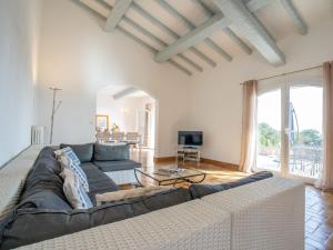 een woonkamer met een bank en een tv bij Holiday Home L'Escarpe des Arbousiers - AGU275 by Interhome in Saint-Aygulf