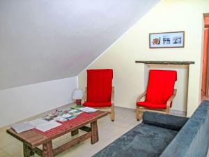 two red chairs and a table in a living room at Apartment Greiweldenger Leit As by Interhome in Greiveldange