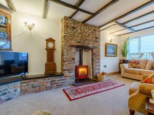 a living room with a brick fireplace and a clock at 3 bed in Brompton 85761 in Brompton