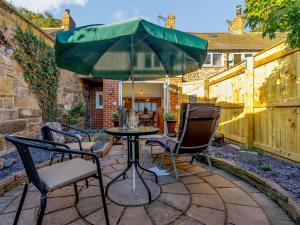 a patio with two chairs and a table with an umbrella at 3 bed in Brompton 85761 in Brompton