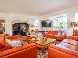 Elle comprend un salon doté d'un mobilier orange et d'une cheminée. dans l'établissement Holiday Home Le Murier by Interhome, à Fréjus