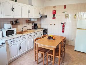 a kitchen with white cabinets and a table with fruit on it at Apartment Duplex Loureiro by Interhome in Ericeira