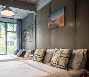 a bedroom with two beds with pillows on it at Pyur Otel by Ombra House in Chiang Mai