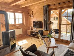 a living room with a fireplace and a tv at Chalet Buchfink by Interhome in Hochrindl