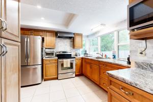 a kitchen with wooden cabinets and stainless steel appliances at Under the Oaks in Jacksonville