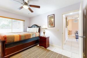 1 dormitorio con 1 cama y ventilador de techo en Under the Oaks, en Jacksonville