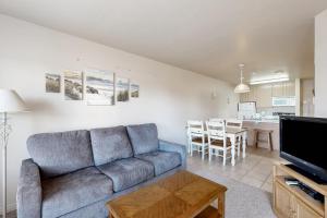 a living room with a blue couch and a kitchen at Harbor Village Pool Building Condo 104 in Garden City