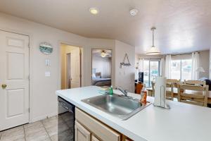 a kitchen with a sink and a counter top at Harbor Village Pool Building Condo 104 in Garden City +13 photos