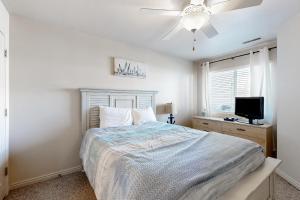 a bedroom with a bed and a flat screen tv at Harbor Village Pool Building Condo 104 in Garden City