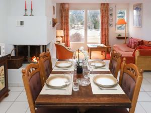 ein Esszimmer mit einem Tisch und einem Kamin in der Unterkunft Apartment Alpes et Lac 2 by Interhome in Champex