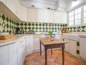 kuchnia z białymi szafkami i drewnianym stołem w obiekcie Holiday Home La Proue by Interhome w mieście Agay - Saint Raphael