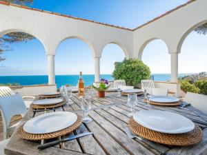 drewniany stół z krzesłami i widokiem na ocean w obiekcie Holiday Home La Proue by Interhome w mieście Agay - Saint Raphael