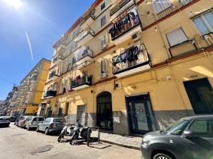a building with cars parked on the side of a street at Luisa Apartments in Naples