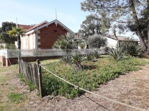 a fence in front of a house at Villa proche plage de l'Amélie - 3057 in Soulac-sur-Mer