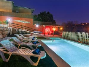 una piscina con tumbonas junto a un edificio en Holiday Home Armonia by Interhome, en Maçanet de la Selva