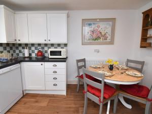 a kitchen with a table with chairs and a microwave at 2 Bed in Caldbeck SZ212 in Caldbeck