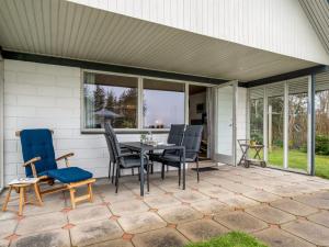 a patio with a table and chairs on it at Holiday Home Moreen - 200m to the inlet by Interhome in Vemb
