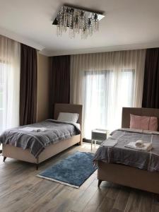 um quarto com 2 camas e um lustre em DSF Villas & SPA A16 em Kırkpınar