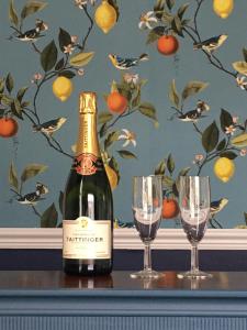 a bottle of champagne and two glasses on a table at The Millbrook B&B in Torquay