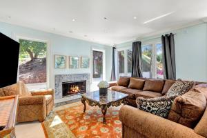 ein Wohnzimmer mit einem Sofa und einem Kamin in der Unterkunft Morgan Hill Elegance Spa & Pool Retreat in Morgan Hill
