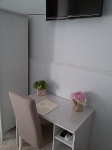 una scrivania bianca con due piante in vaso di I Marinaretti a Siracusa