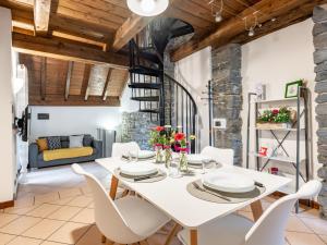 una sala da pranzo con tavolo e sedie bianchi di Holiday Home Silvia by Interhome a Mergozzo