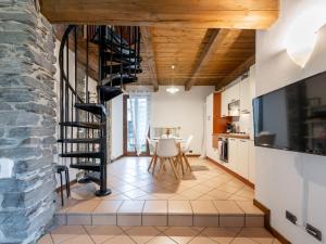 a living room with a spiral staircase and a table at Holiday Home Silvia by Interhome in Mergozzo