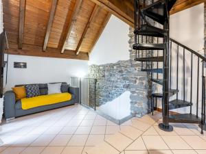 a living room with a couch and a stone wall at Holiday Home Silvia by Interhome in Mergozzo