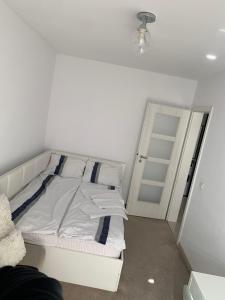 a white bed in a room with a door at Apartament Vila Brana Sibiu Selimbar str Nicolae Brana Nr 63 Ap 4 in Şelimbăr
