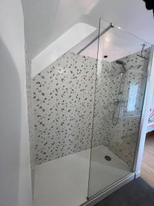 eine Dusche mit Glastür in einem Zimmer in der Unterkunft Maison rénovée à Agon-coutainville proche de la mer, classé meublé de tourisme 3 étoiles in Agon Coutainville + 18 Fotos