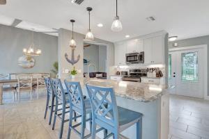 a kitchen and dining room with blue chairs and a counter at Bonita Springs Getaway With Pool and Spa in Bonita Springs