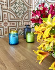 un tavolo con tre candele e un mazzo di fiori di La Vetrana Rooms ad Avetrana