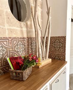 a bathroom with a mirror and flowers on a counter at La Vetrana Rooms by Jdvacanze in Avetrana