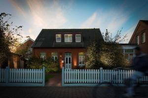 a house with a white fence in front of it at FeWo Lina in Borkum