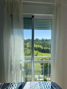 sypialnia z łóżkiem i dużym oknem w obiekcie Baviera Golf Vacations w mieście Vélez-Málaga