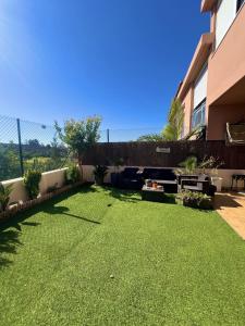 podwórko z zieloną trawą i ogrodzeniem w obiekcie Baviera Golf Vacations w mieście Vélez-Málaga