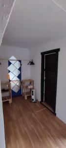 um quarto com uma porta preta e piso de madeira em Rincon de Valdaliga em Valdaliga 