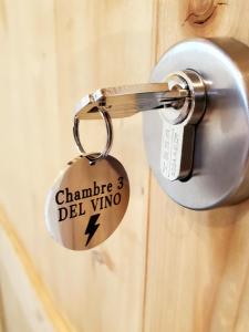 eine Schlüsselkette mit an eine Tür geketteten Wörtern in der Unterkunft DEL VINO bar à vin & guitares in Orchamps-Vennes