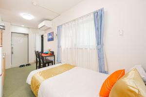 Un dormitorio con una cama y una ventana y un escritorio. en KYARA Hotel 402, en Tokio
