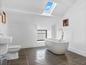 La salle de bains blanche est pourvue d'une baignoire et de toilettes. dans l'établissement 14 Fountain House Ulverston Pass the Keys, à Ulverston