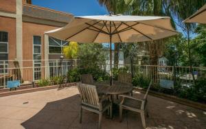 a table and chairs with an umbrella on a patio at Sj Elite Loft Sleek Sophistication in San Jose